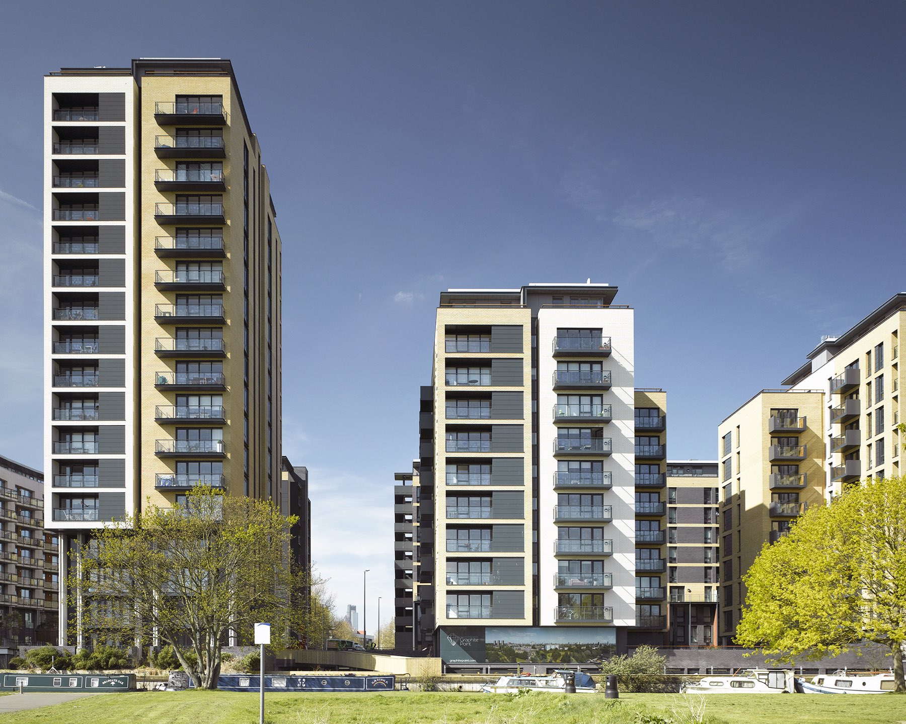 Sutton's Wharf from the canal towpath: Grand Regent Tower, Graphite Point and neighbouring blocks under a blue sky